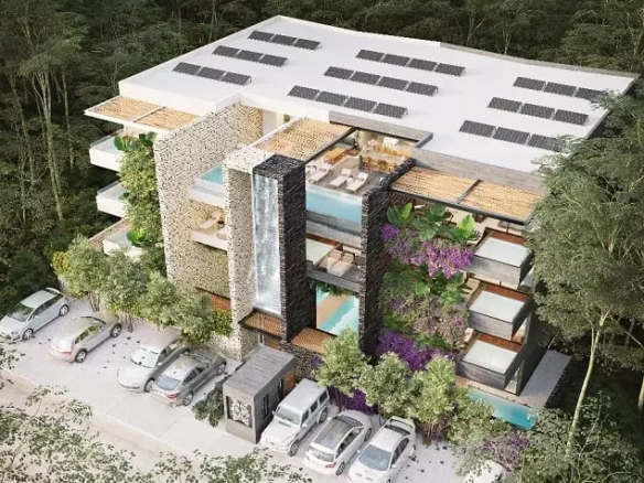 Facade of a residential building with some swimming pools and cars parked in front, surrounded by jungle in Xexen and Xakah