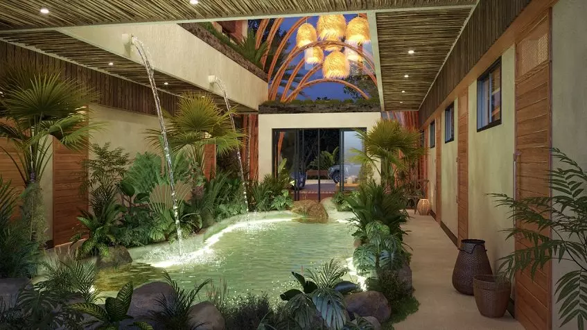 Jardín de la piscina en la planta baja rodeado por un corredor y pocas puertas durante la noche en Ocean Condos Tulum