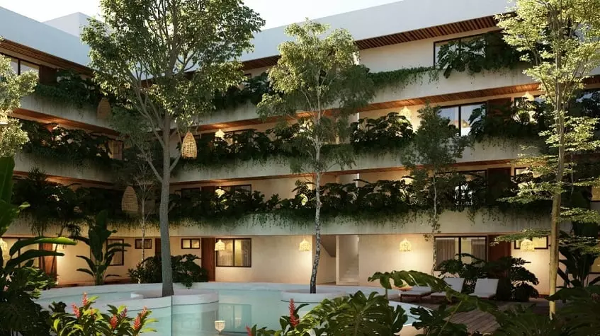Edificio residencial con algunas plantas dando vueltas en Canopia Tulum Condos