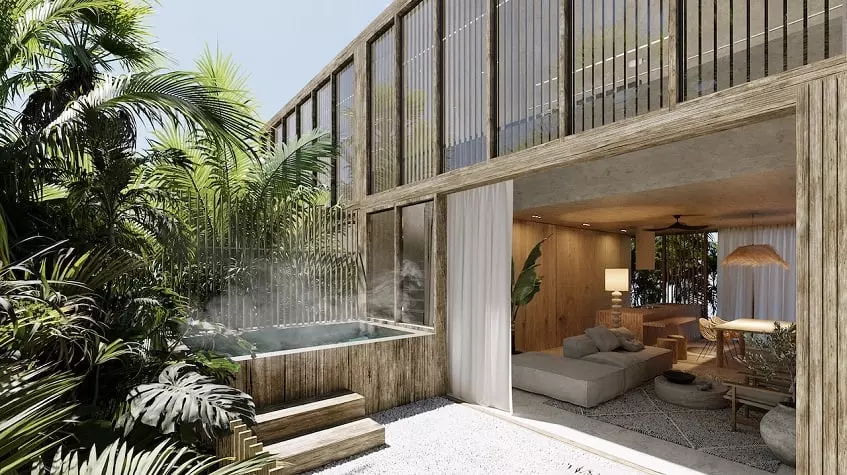 Sala de estar con puerta corrediza abierta para terraza con piscina en Miraval Tulum
