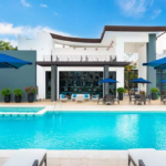 Une piscine avec parasols et chaises longues à Altaria Residencial