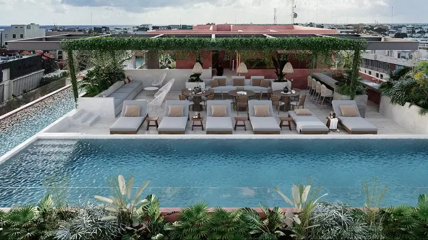 Una terraza con alberca, camastros y un area lounge en Ikuku Playa del Carmen