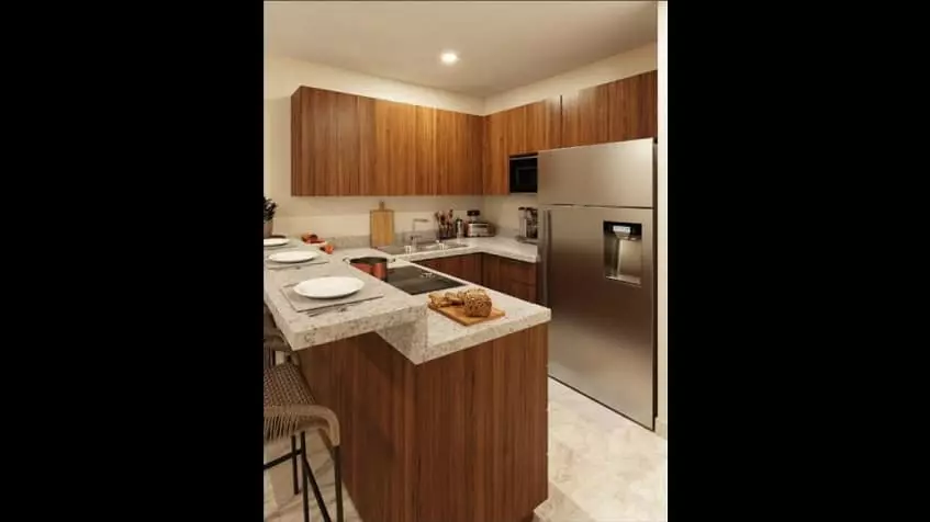 Una cocina, una barra desayunadora de granito y un refrigerador en Nala Cozumel