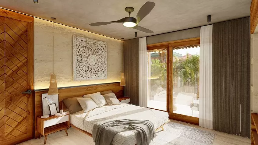 Una recamara con cama matrimonial, un ventilador y una ventana con vista al balcon el Eden Playa del Carmen