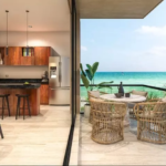 A kitchen with a balcony and a dining room with ocean views in Bajareque Telchac
