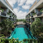 Dos fachadas de edificios y una alberca en el medio en Core Tulum