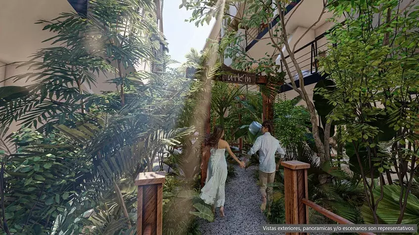Jardin et un couple en train de marcher, balcons de certains appartements à Zamajal Tulum