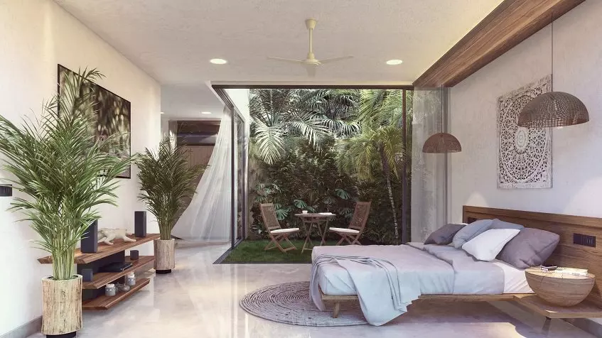 Recamara con terraza verde y pequeña mesa y sillas de jardín en Yum Lum Tulum