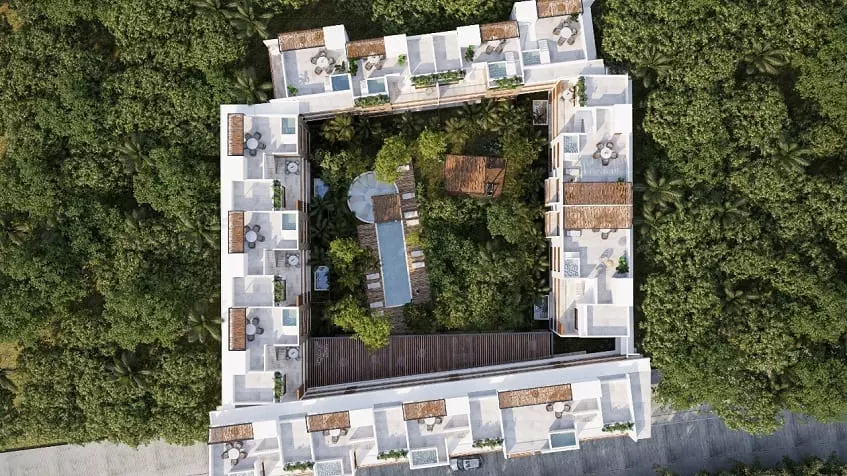 Vista aérea de un edificio residencial con jardín de piscina en el medio en Oriana Tulum