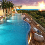 Une grande piscine avec chaises longues et transats à Nequen del Mar Tulum