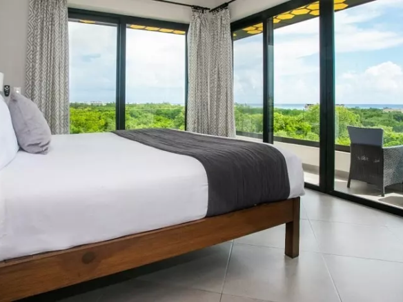 Una recamara con balcon y vista al mar en Honey B Residences