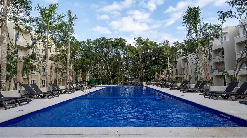 A pool overlooking the trees and apartments at La Selva Residences