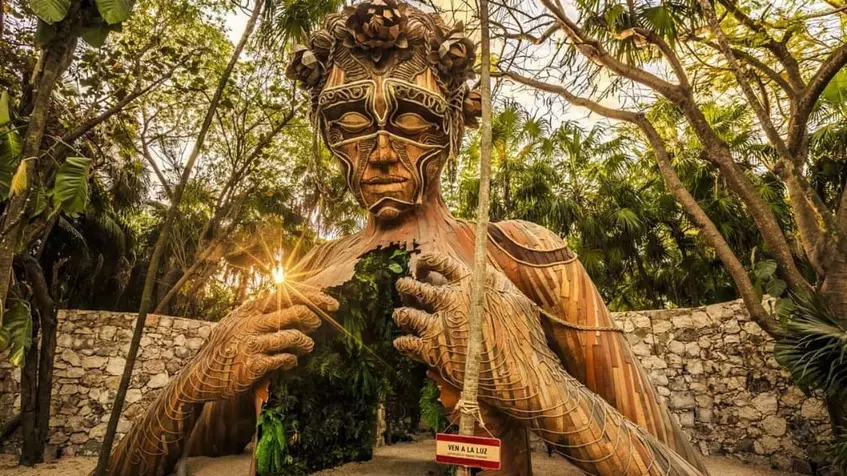 Una estatua de madera en forma de mujer en Tulum
