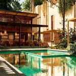 A pool, a bar, and lounge chairs at Casas Maxia Tulum