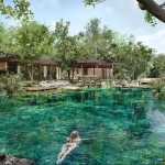 Un cénote avec une femme nageant à Selvanta Tulum