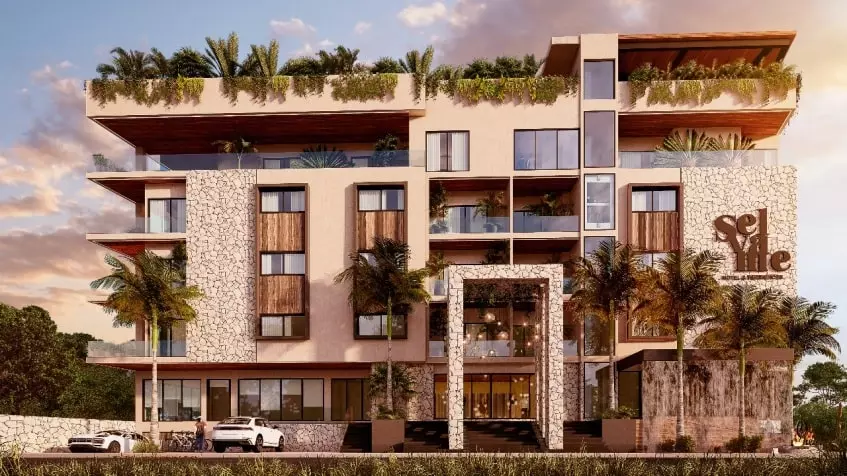 Una fachada de un edificio con autos estacionados afuera en Selva Me Tulum