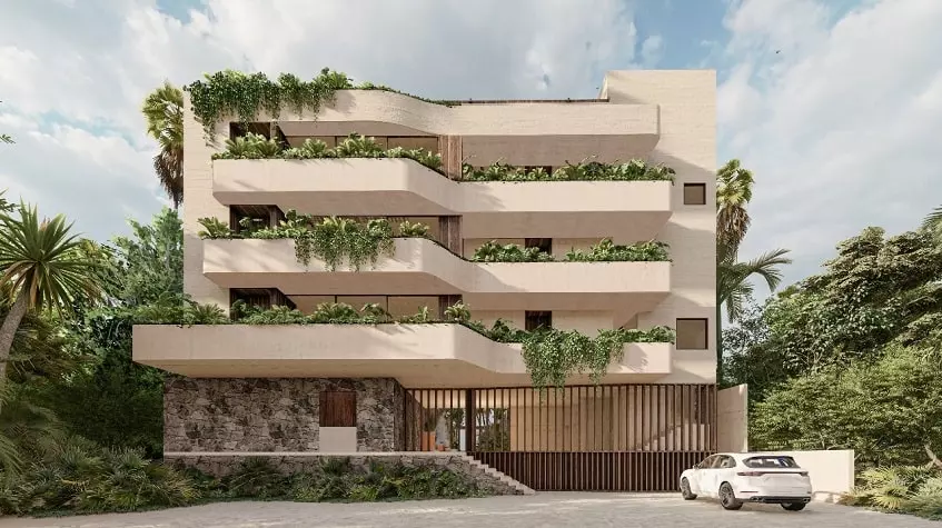 Fachada de un edificio de departamentos y un auto estacionado en Bahia Tulum