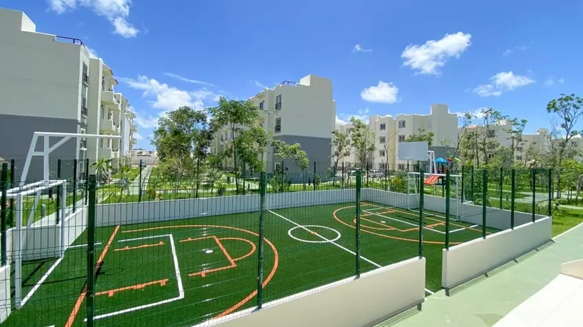 Una cancha de futbol abierta con jardines alrededor en Aldea Tulum Plus