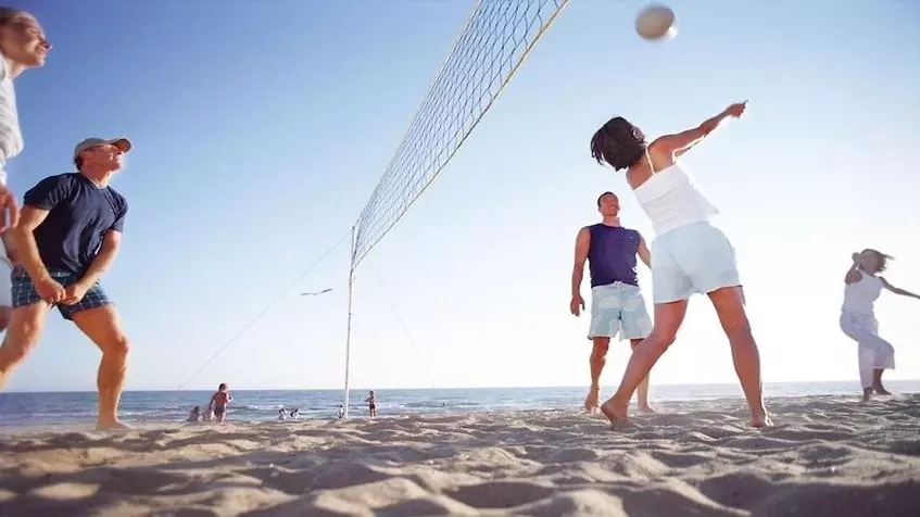 Un grupo de estadounidenses jugando en la playa volleyball