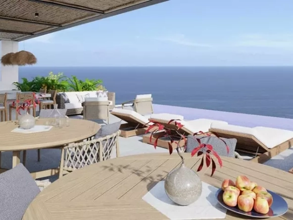 Una terraza con camastros, mesas y sillas con vista al mar en Elysium