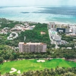 Aerial view of a golf course and waterfront buildings in Hoxul