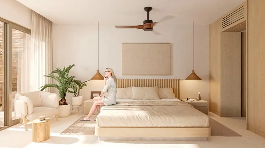 Una mujer sentada en una cama hablando por telefono en Coko Tulum
