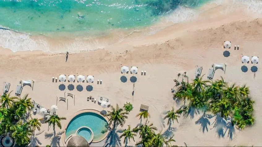 Vista aerea de un club de playa con sombrilllas en Punta Laguna