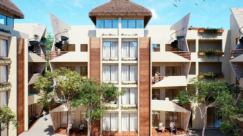Fachada de un edificio de departamentos con personas sentadas en Naia Uhm Tulum