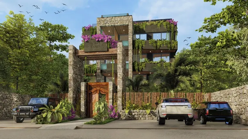 Una fachada de una torre de departamentos y un estacionamiento con jardines alrededor en Malek Tulum