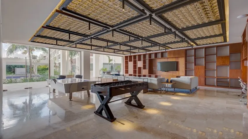 un salon des résidences avec des jeux au beloved residences playa mujeres