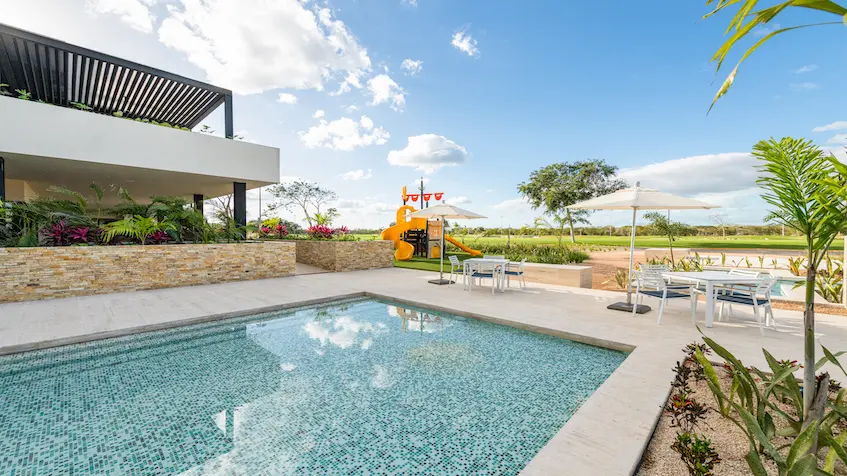 Swimming pool next to children's playground in Merida Residential Province