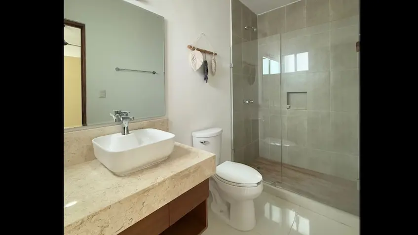 Une salle de bains avec douche en verre et lavabo au Zentrik Tulum Estudios.