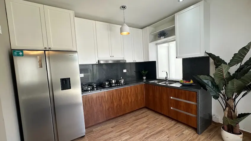 A kitchen with white cabinets and stainless steel fridge in Samala Playa del Carmen