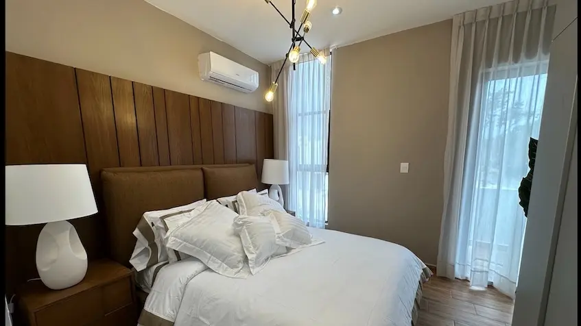 A bed with white sheets and pillows at Samala Playa del Carmen