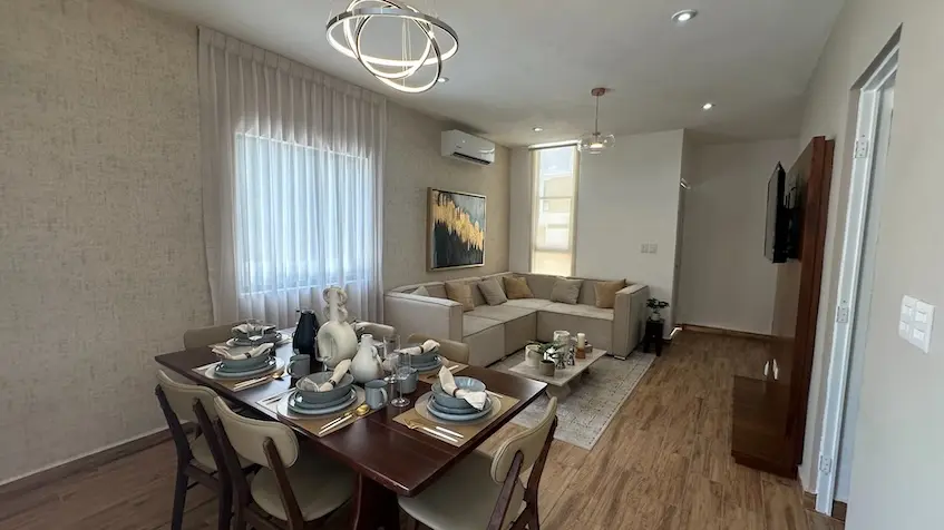 A dining table and a sofa in a room at Samala Playa del Carmen