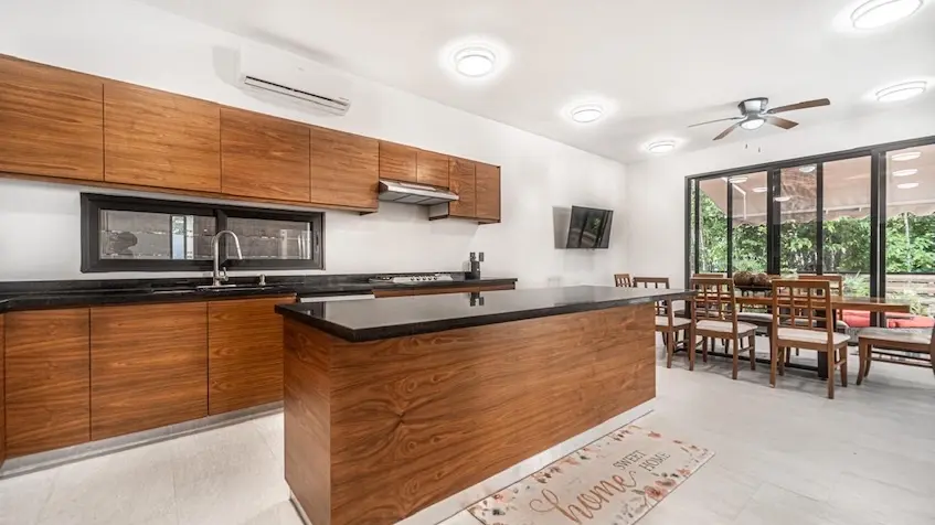 Una cocina integral con isla y comedor en Casa en Venta en Senderos Mayakoba en Playa del Carmen
