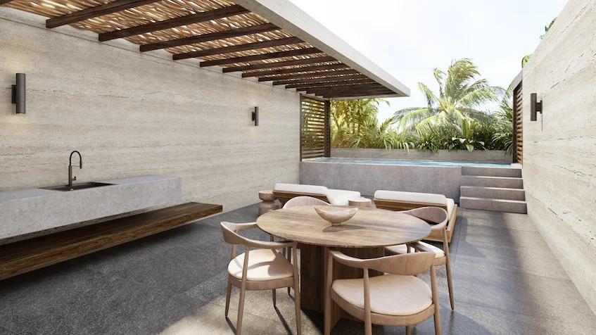 Rooftop privado que incluye una mesa redonda de comedor con sillas de madera, camastros, una alberca tipo jacuzzi, pérgola de madera y muros de piedra de Luum Kan Cancún