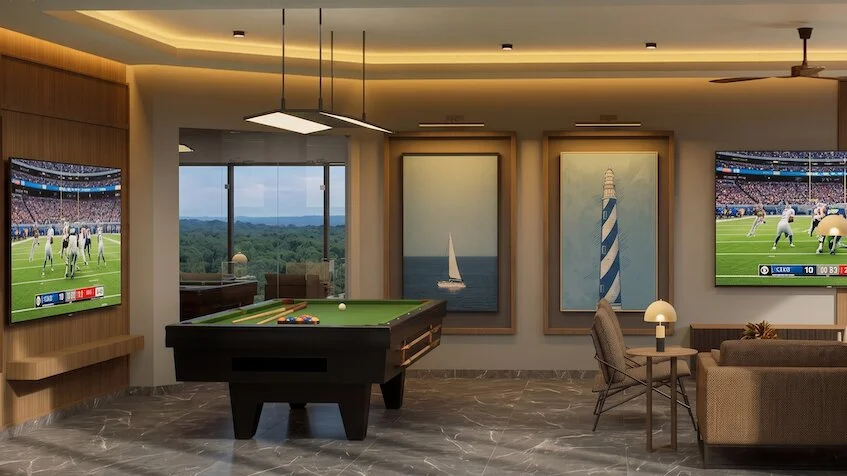 Área de entretenimiento que incluye una mesa de billar, pantallas de televisión con partidos deportivos, cuadros decorativos en la pared, un sillón y una lámpara de pie de Sensum Puerto Morelos