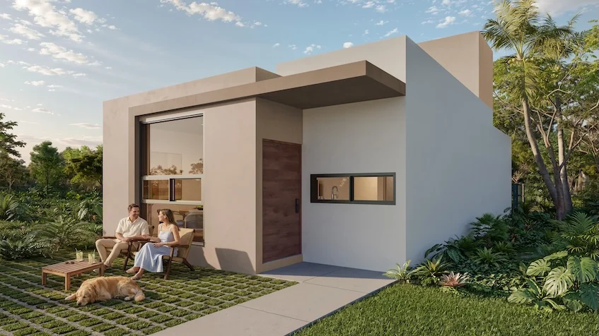 Fachada frontal de una residencia que incluye un diseño arquitectónico de un nivel con un porche exterior, áreas verdes con césped y plantas, y un muro con acabado claro de The Origin By Gran Selva Puerto Morelos
