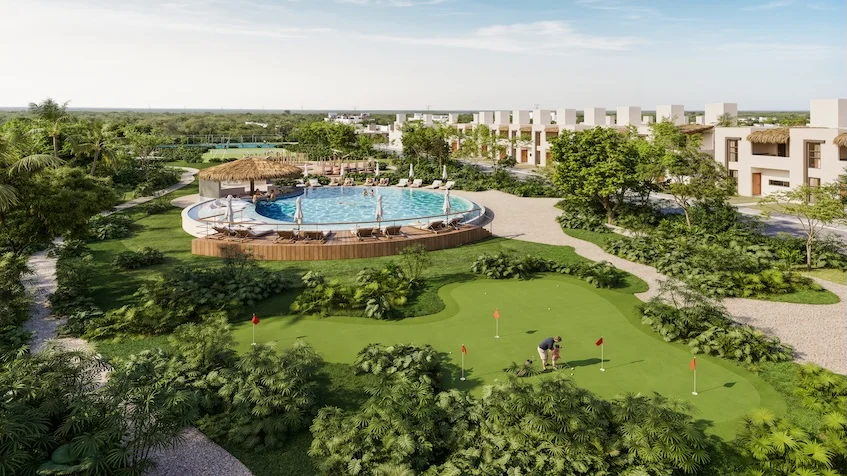 Área de minigolf que incluye un campo de golf, una alberca circular con palapa, amplias áreas verdes, árboles y edificios residenciales al fondo de The Origin by Gran Selva Puerto Morelos.