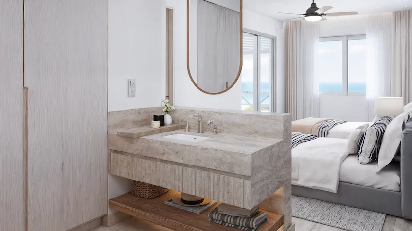 Recámara que incluye dos camas, clósets, un área de lavabo con espejo y un ventilador de techo de Isola BLU Isla Mujeres.