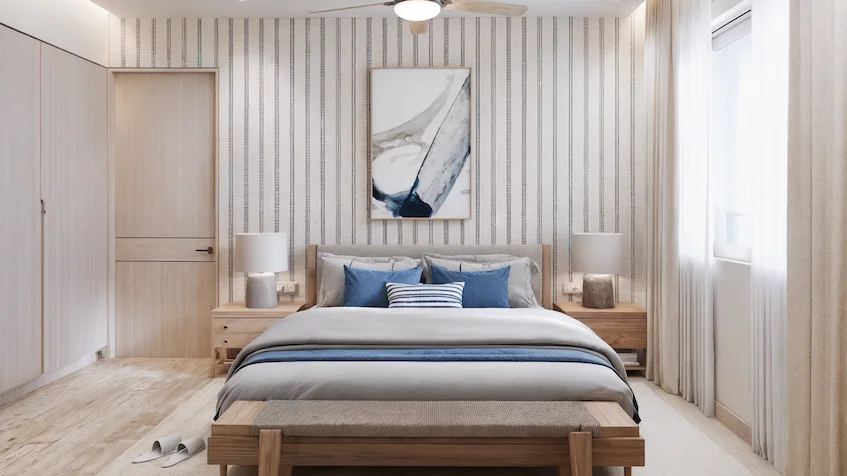 Recámara principal que incluye una cama, burós con lámparas, una banca, clósets y un ventilador de techo de Isola BLU Isla Mujeres.
