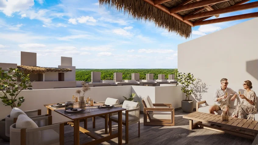 Vista de un rooftop que incluye una terraza con comedor exterior, una pérgola de madera con techo de palma, macetas con plantas, edificios circundantes y la selva al fondo de The Origin by Gran Selva Puerto Morelos.