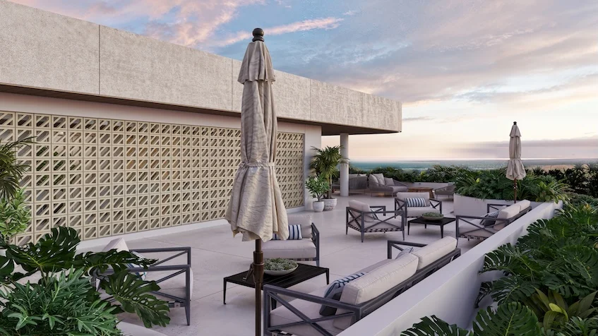Terraza al aire libre equipada con salas lounge compuestas por sillones sofás con cojines mesas de centro bajas y sombrillas plegadas con vista al mar de Village Blu Puerto Morelos