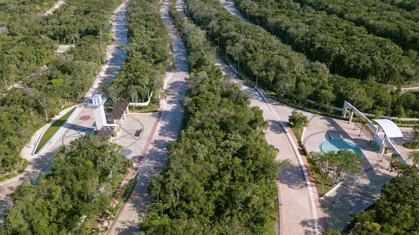 Vista aérea del acceso principal y avenidas rodeadas de selva en Entre Bosques Mayakobá Playa del Carmen